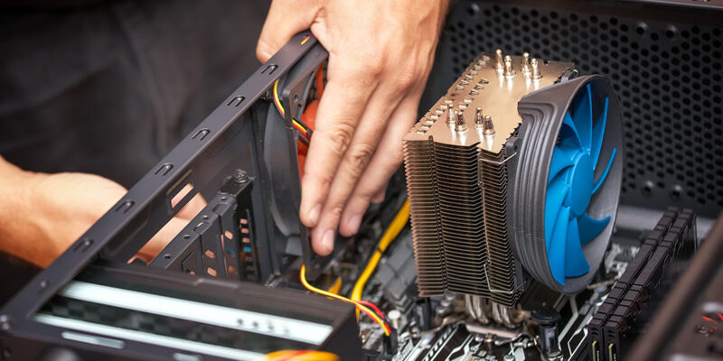Computer technician installs cooling system of computer. Assembling PC